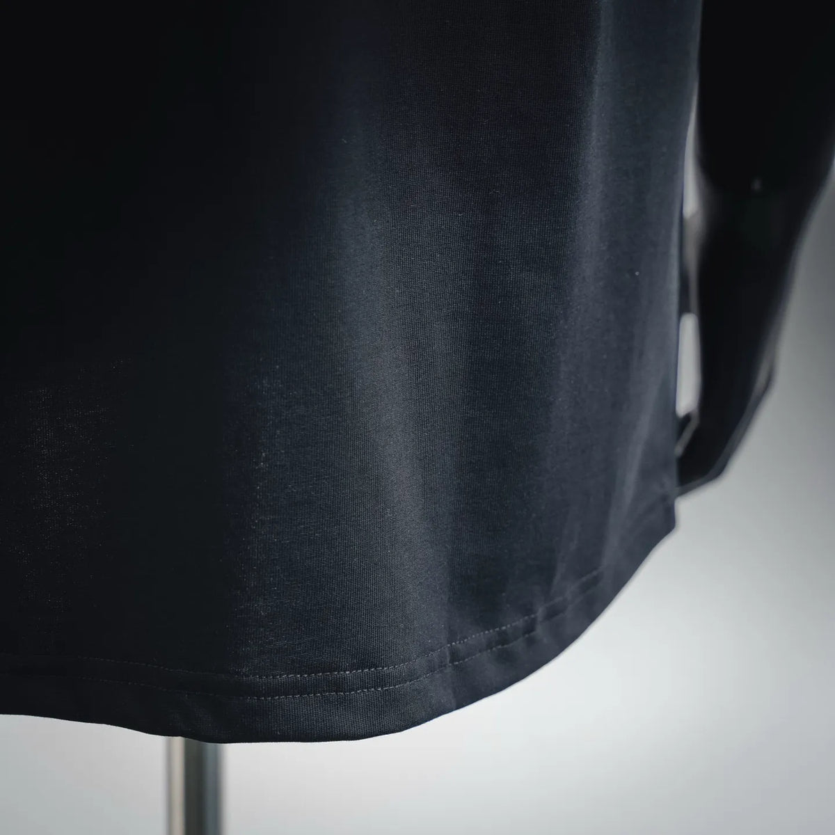 Black short-sleeve T-shirt hem and fabric close-up