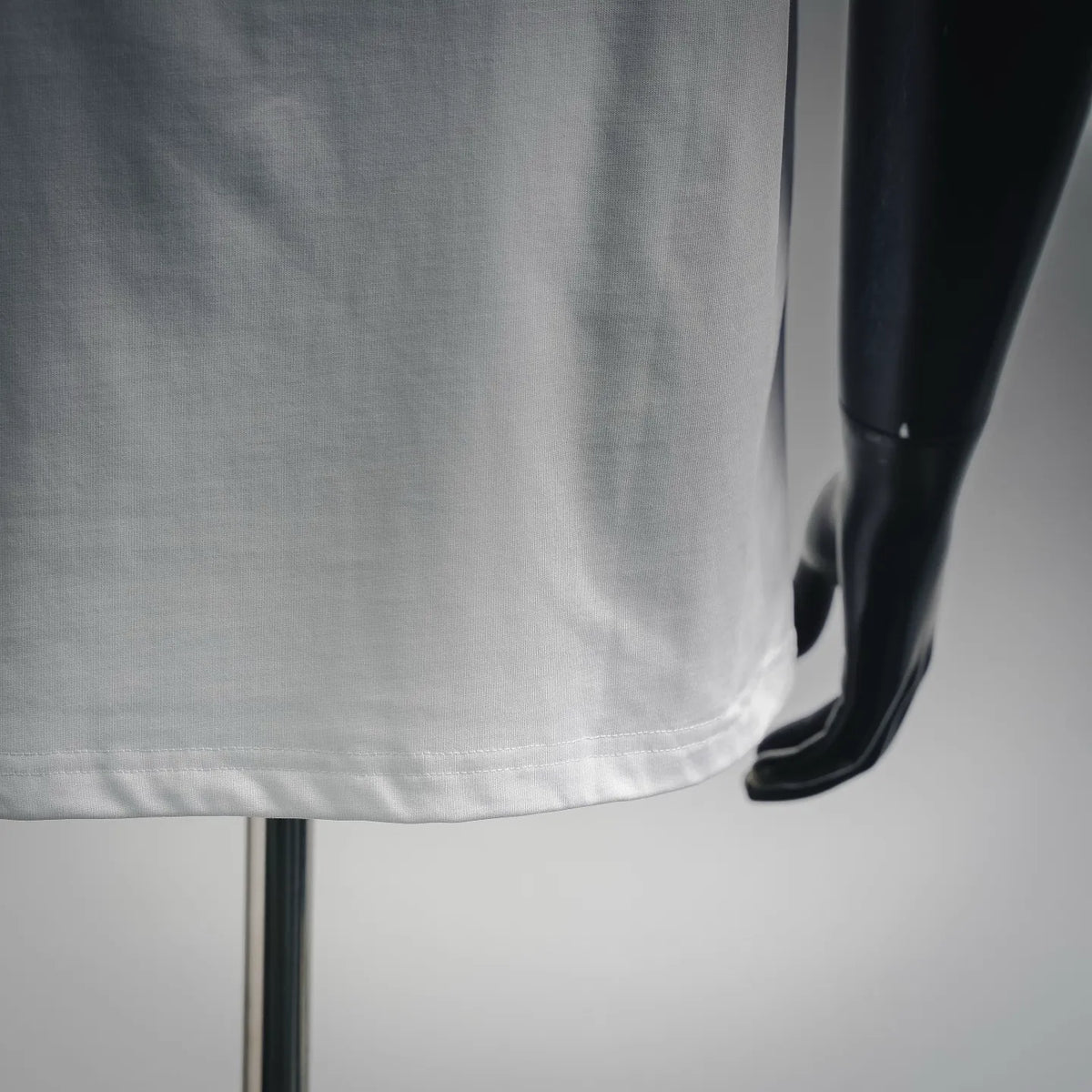 White short-sleeve T-shirt hem and side seam detail on a mannequin