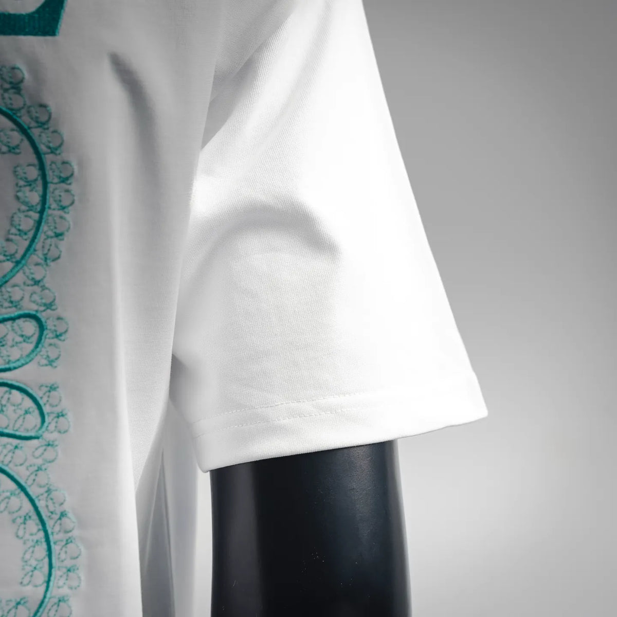 White short-sleeve T-shirt sleeve cuff with teal graphic edge