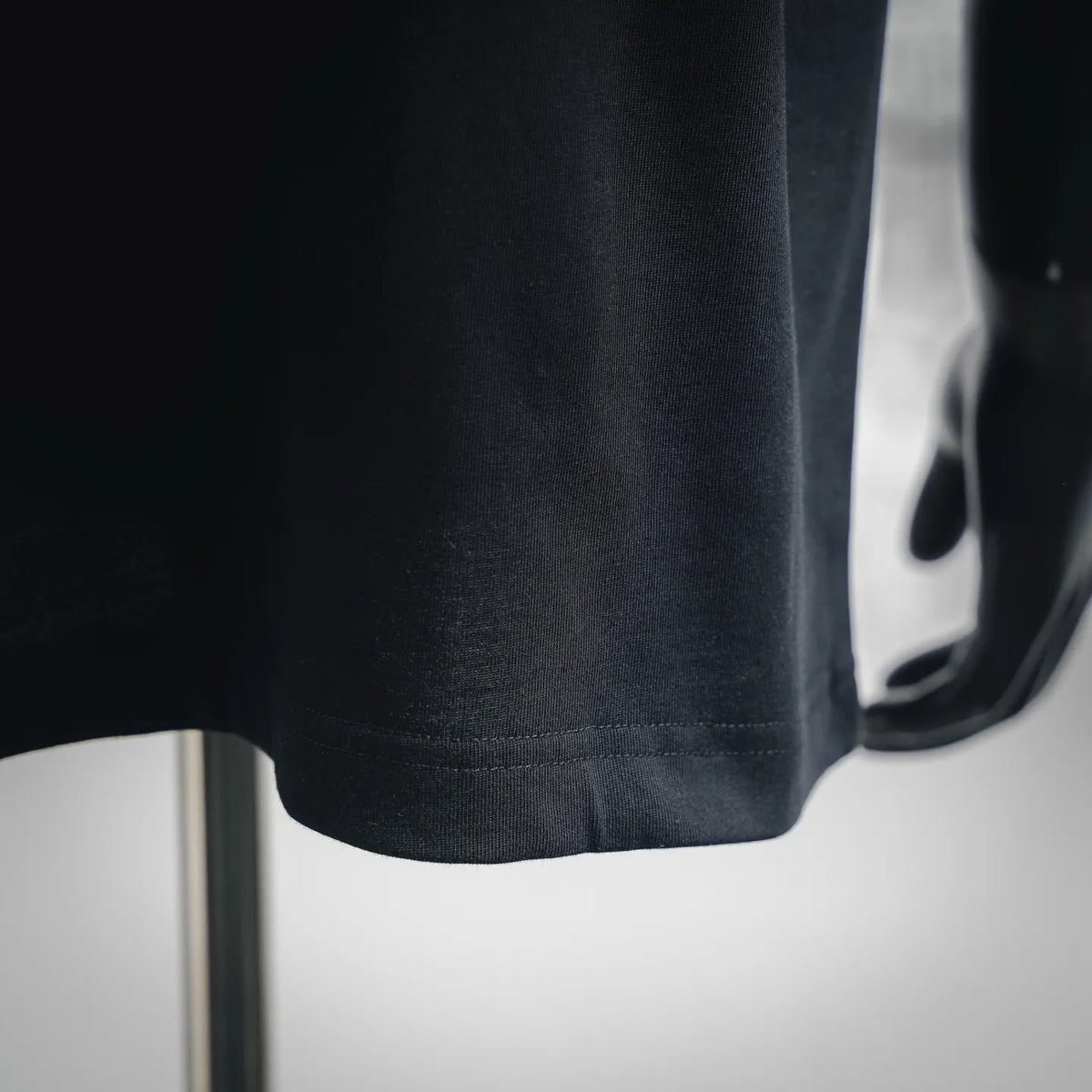 Black short-sleeve T-shirt hem with stitched bottom edge