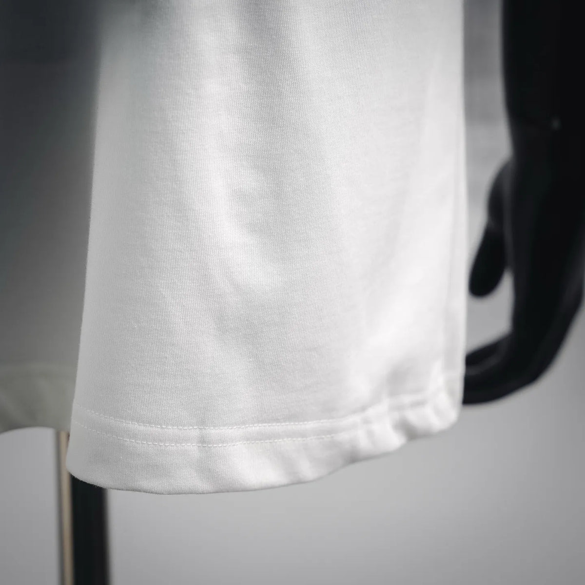 White T-shirt hem with visible stitching detail