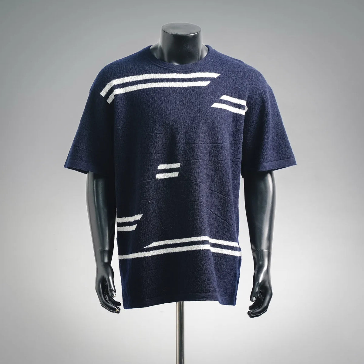 Navy short-sleeve knit sweater with white graphic stripes on the front