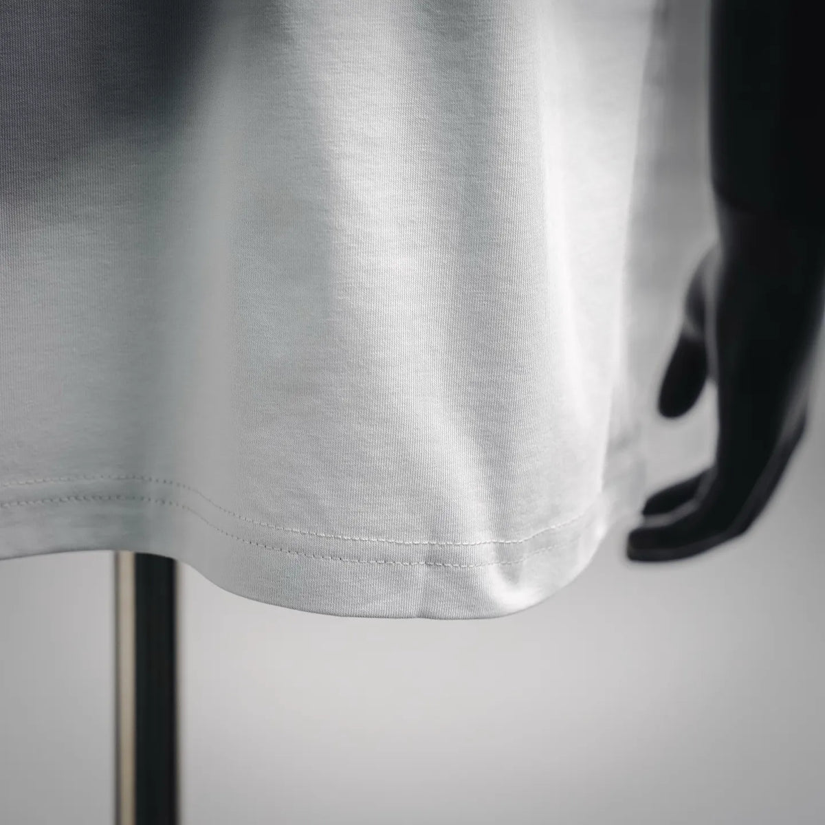 White LOEWE T-shirt hem and side seam close-up.