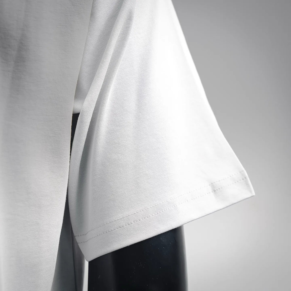 White LOEWE T-shirt sleeve and bottom hem close-up.