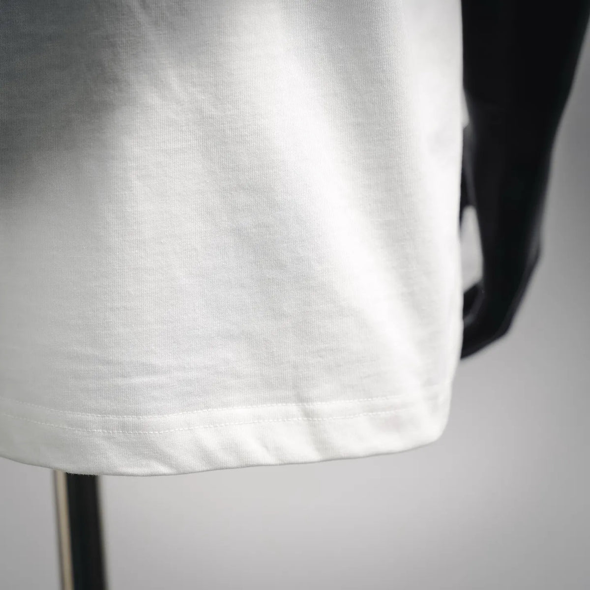 Close-up of white T-shirt front hem and fabric texture