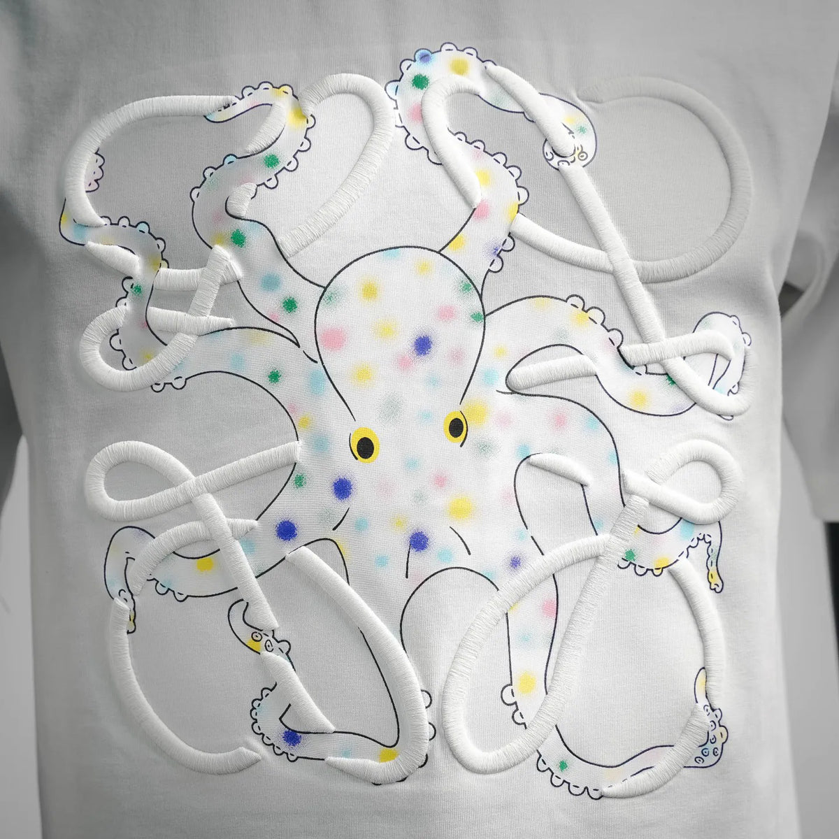 White LOEWE T-shirt with large colorful cartoon character graphic on the chest