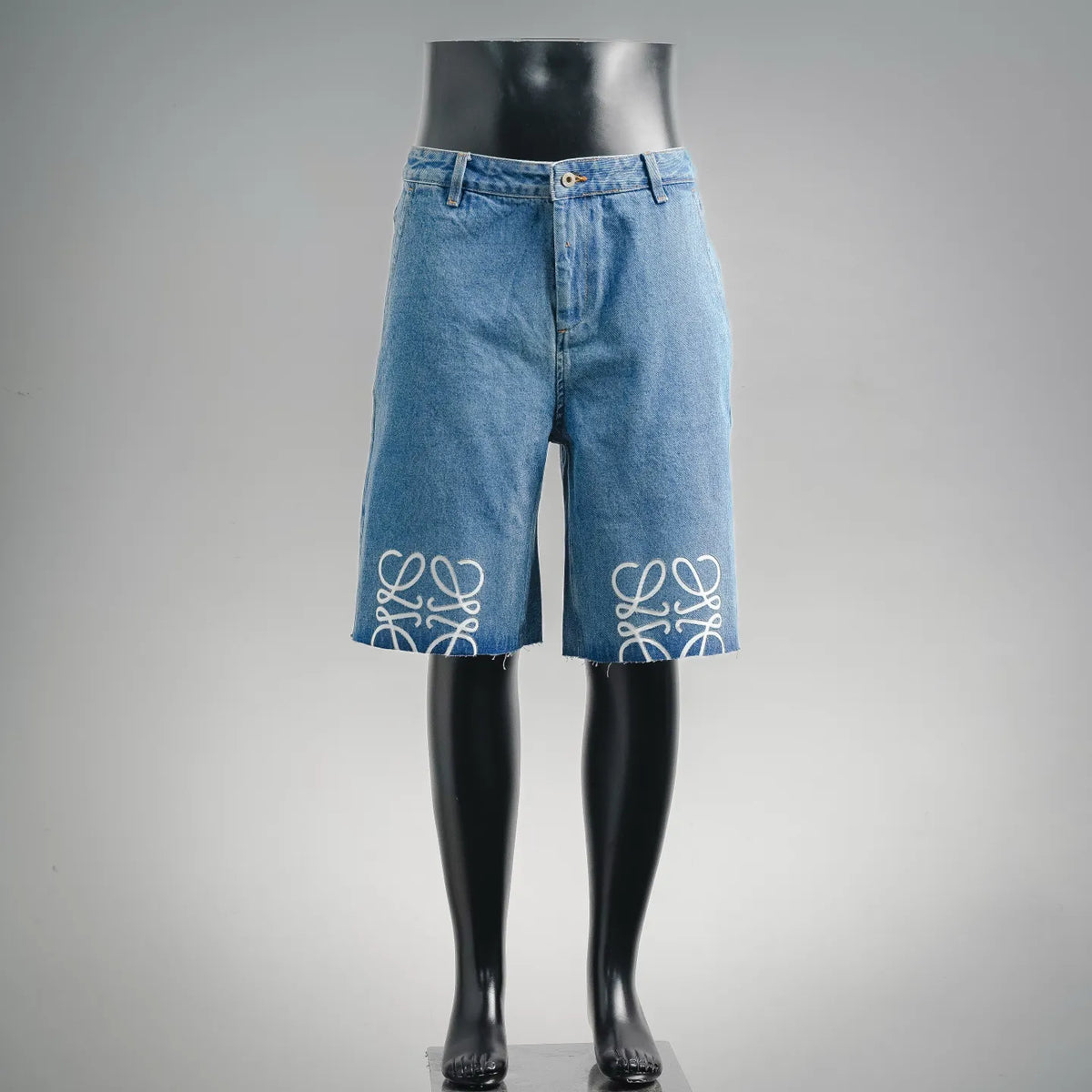 Blue denim shorts with embroidered white logo on lower legs