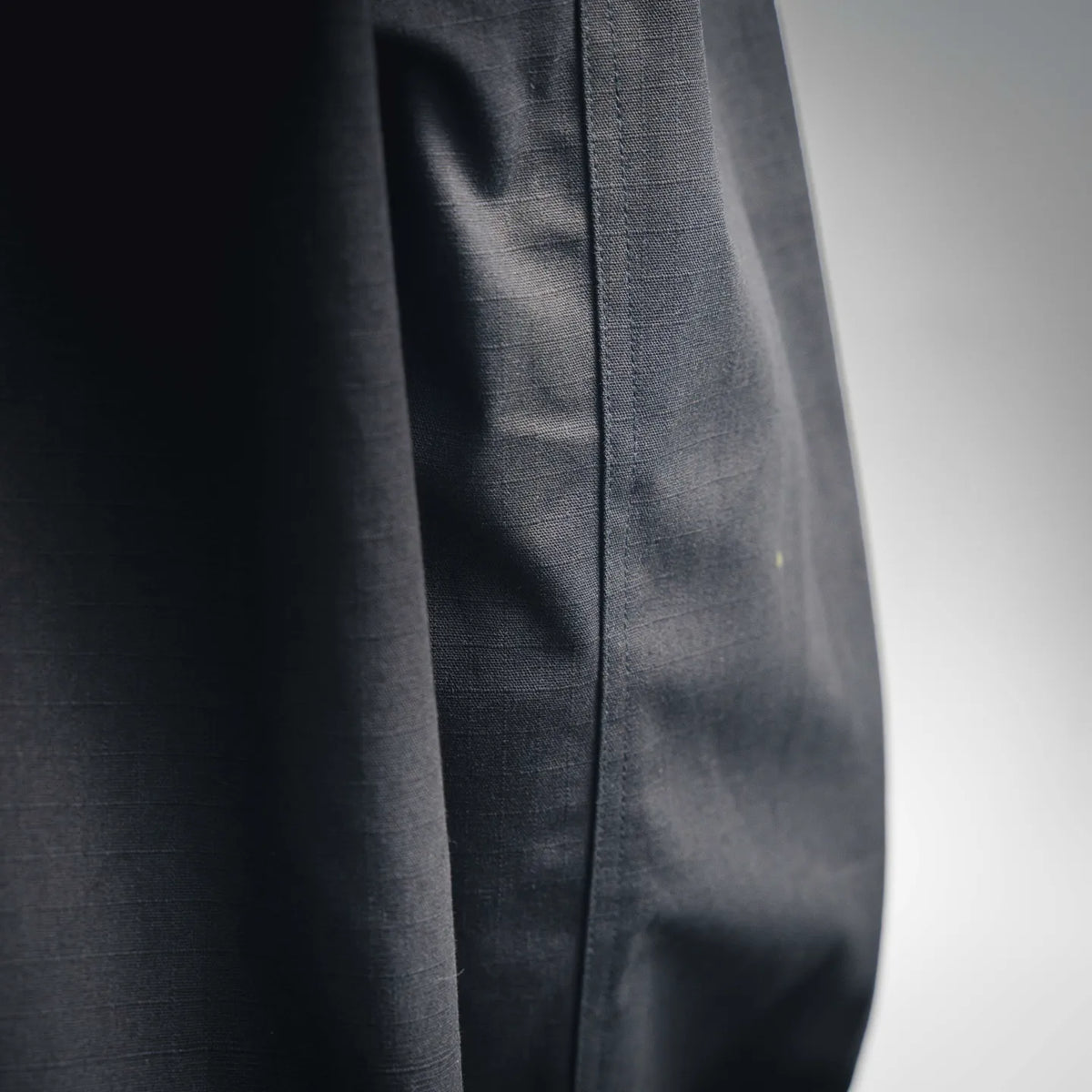 LOEWE coat front panel seam detail on dark fabric