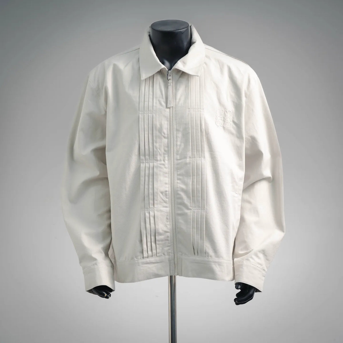 White LOEWE coat with front zipper and pointed collar on mannequin