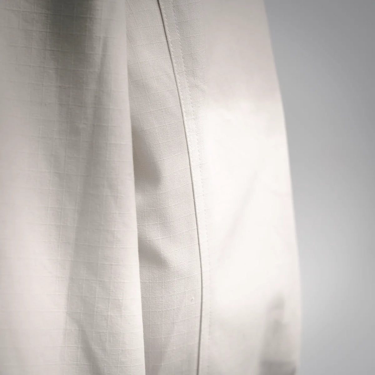 White coat fabric panel with vertical seam stitching