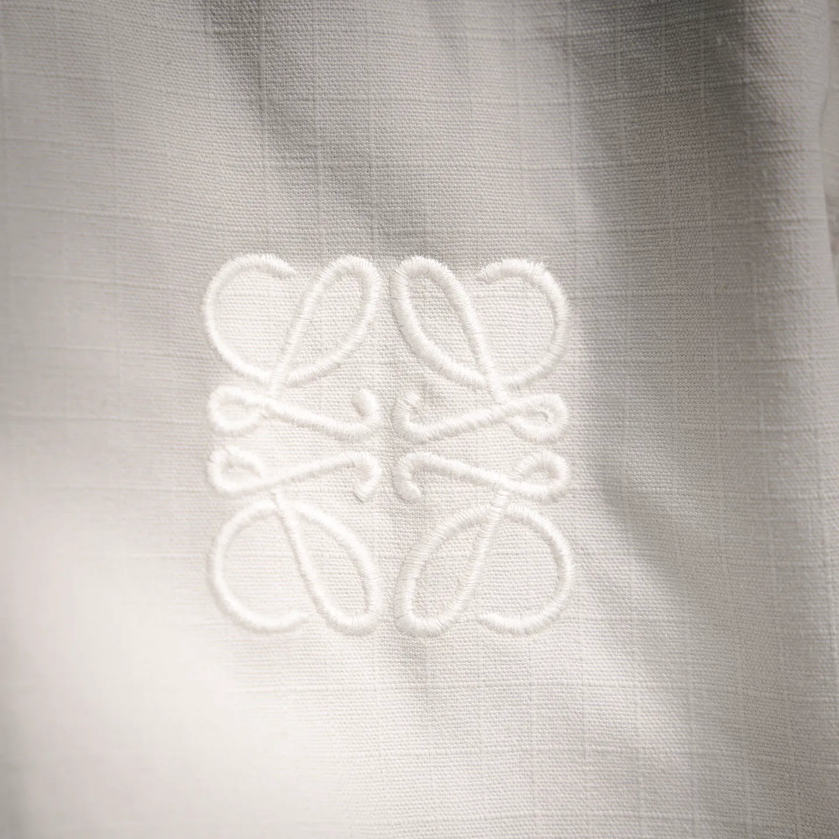 Embossed LOEWE monogram on white coat fabric