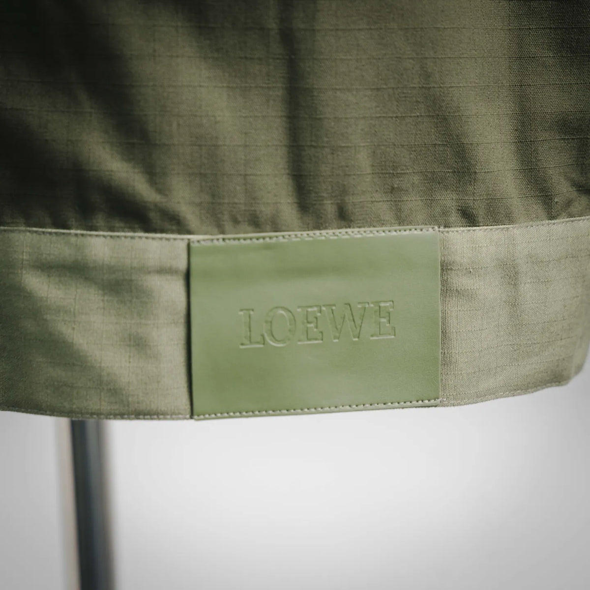 Olive green fabric label with LOEWE text stitched inside waist band