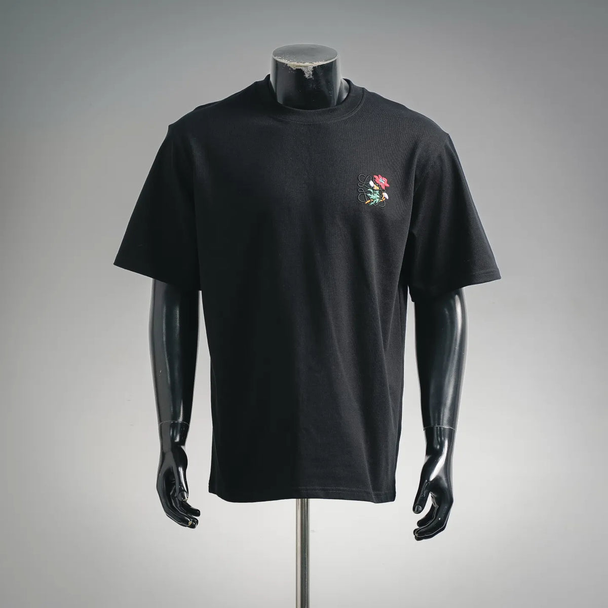 Black crewneck short-sleeve T-shirt with colorful embroidered graphic on chest