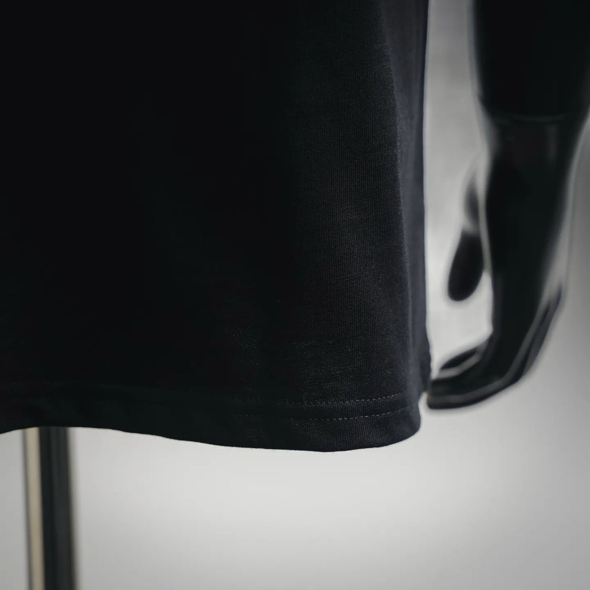 Black T-shirt hem and side seam, knit fabric close-up