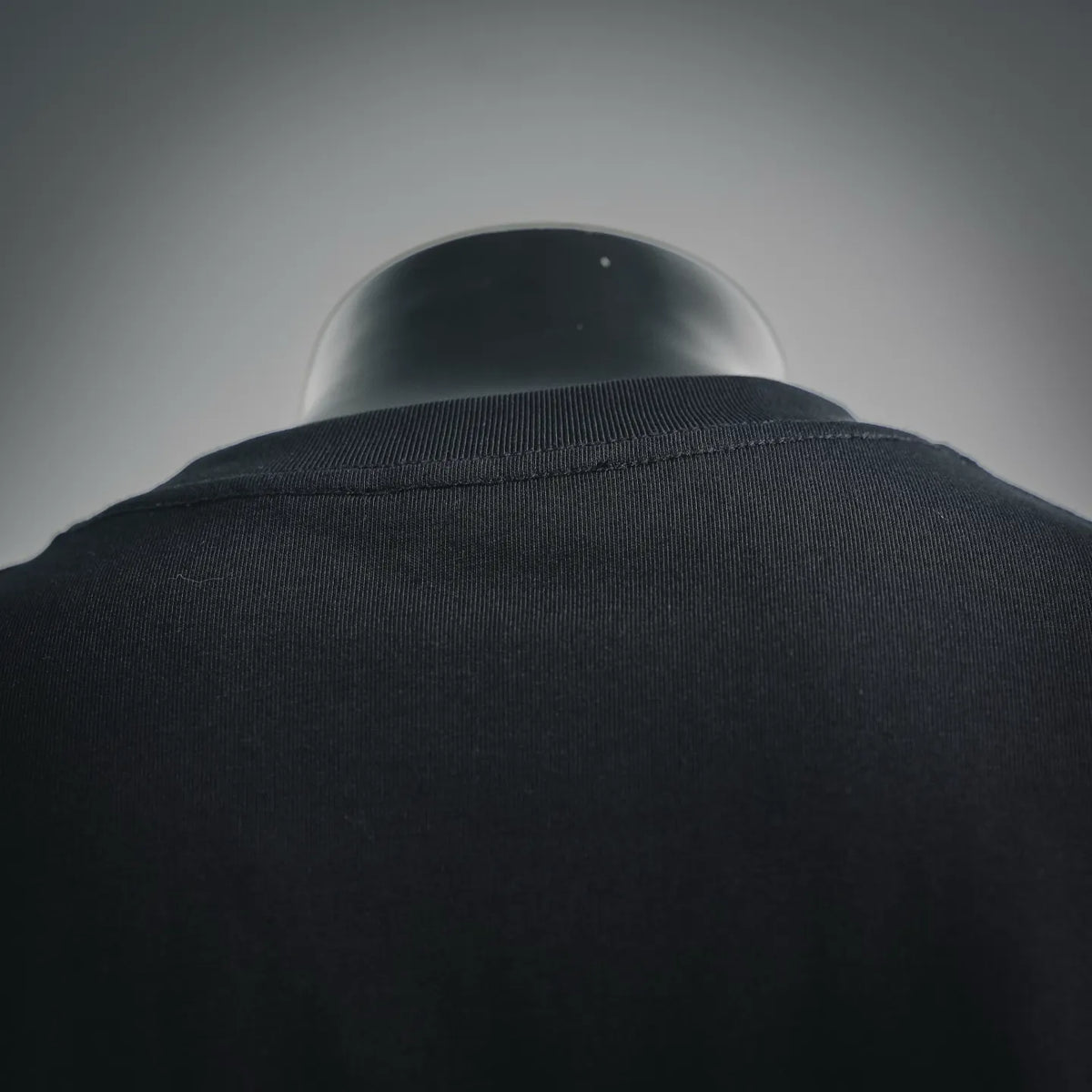 Black T-shirt back collar with ribbed neckline, fabric texture close-up