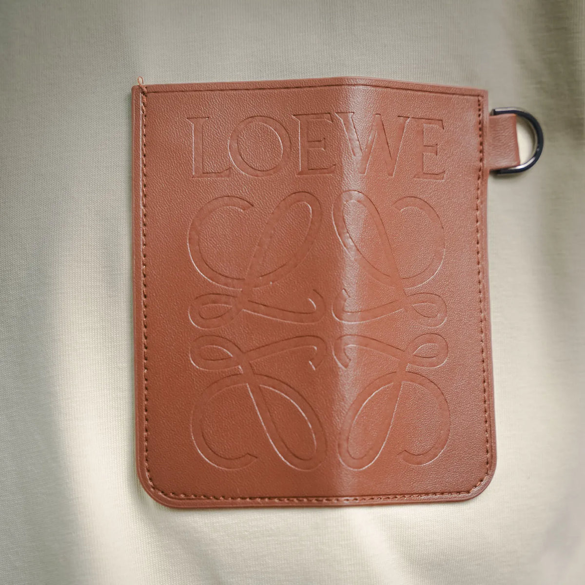 Square brown LOEWE embossed logo patch on T-shirt chest pocket