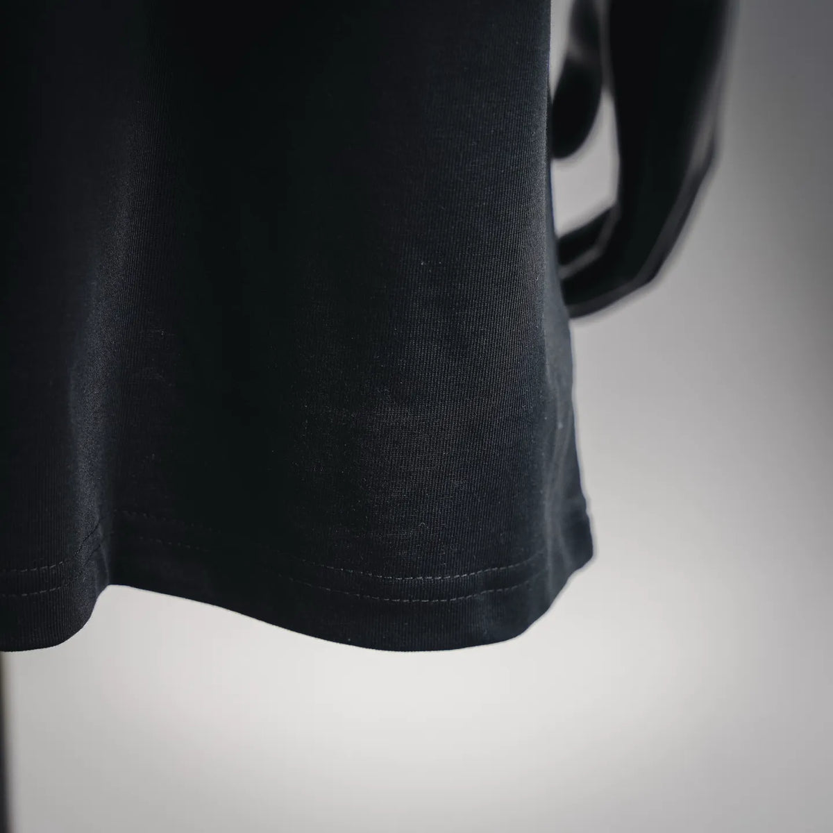 Black T-shirt hem with neat double-stitched edge.