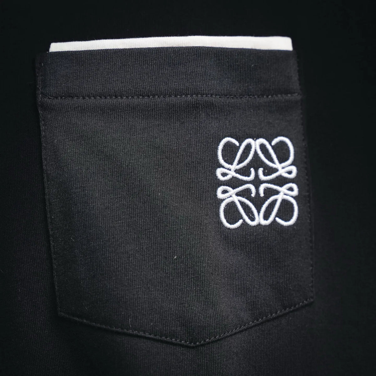 Black chest pocket with white LOEWE-style line logo