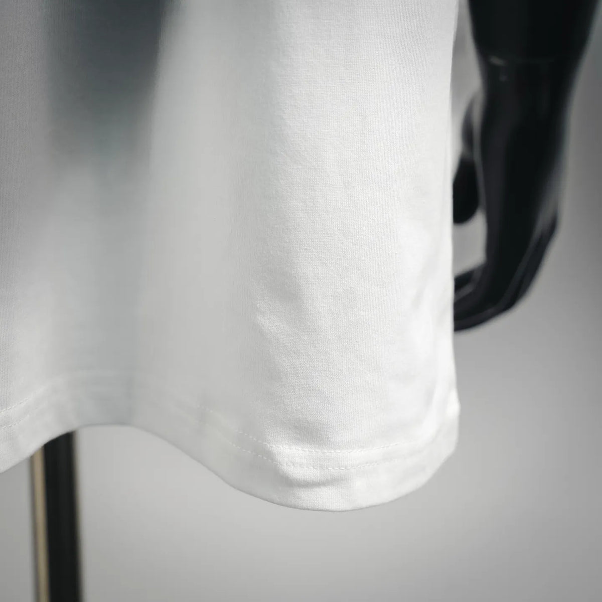White short-sleeve T-shirt hem close-up with smooth fabric texture