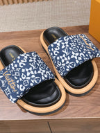 Louis Vuitton slide sandals, blue patterned band over black footbeds and tan rubber soles