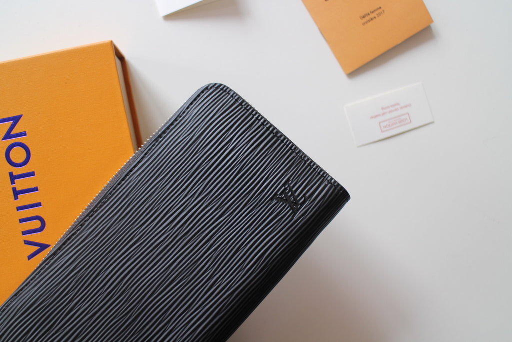 Textured dark leather zip wallet front with Louis Vuitton logo hardware detail
