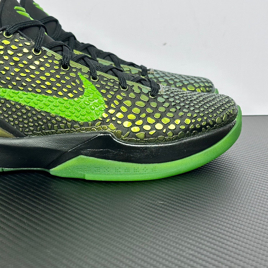 Black and green basketball shoe with textured pattern, neon laces, and bright green sole.