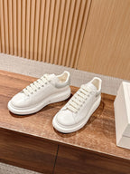 Alexander McQueen leather sneakers, white lace-up, side view with thick sole