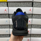 Black and teal basketball shoe rear with glossy heel panel and blue collar lining.