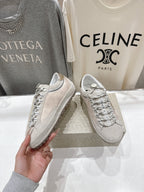 Golden Goose light gray lace-up sneaker shown in hand, with patterned laces