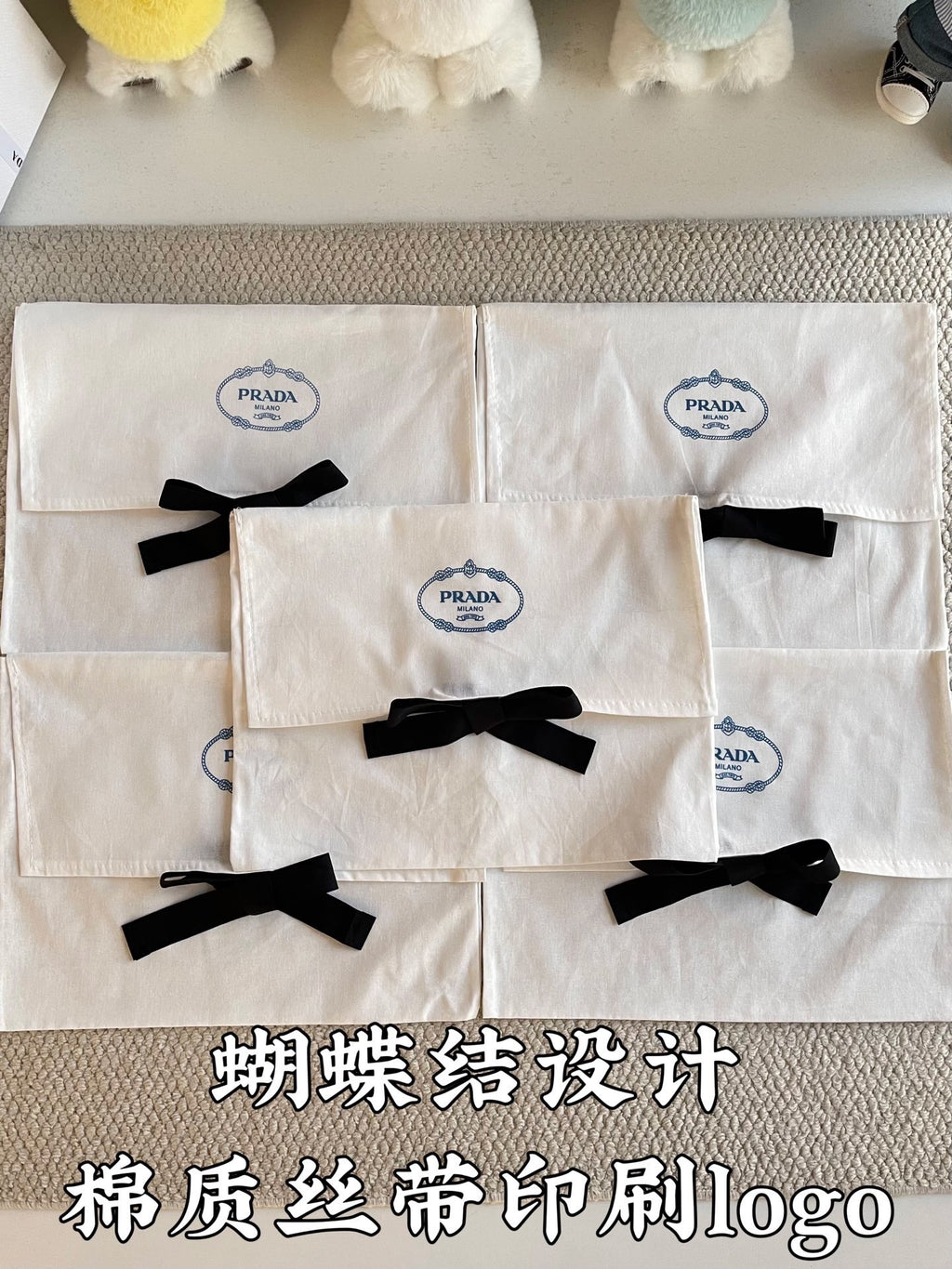 White Prada gift bags with black ribbon bows, front view close-up