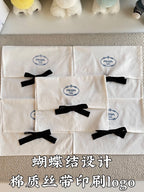 White Prada gift bags with black ribbon bows, front view close-up