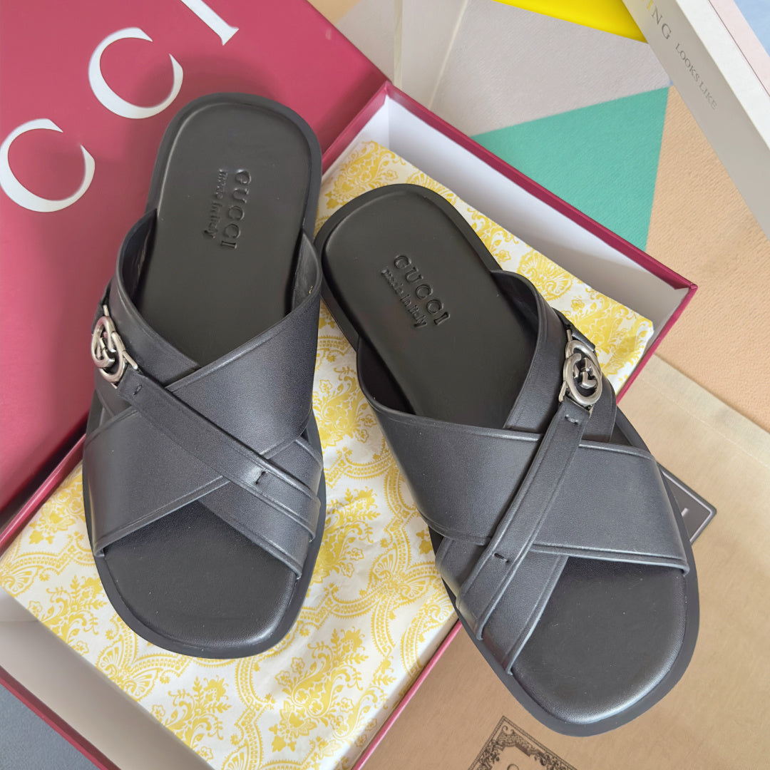 Gucci black slide sandals with crossover straps and silver G buckle detail