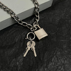 Silver-tone chain bracelet close-up with padlock charm and two keys