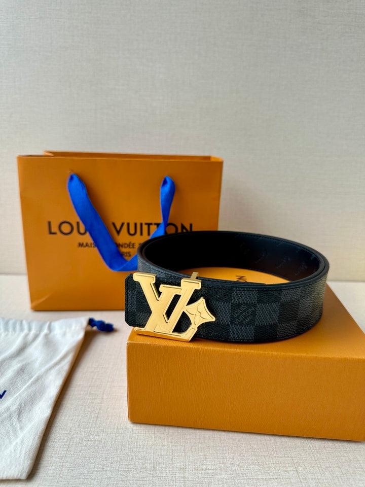 Dark patterned leather belt with gold-toned LV buckle, resting on boxes.