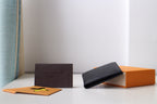 Louis Vuitton small black textured leather pouch lying flat with folded top edge