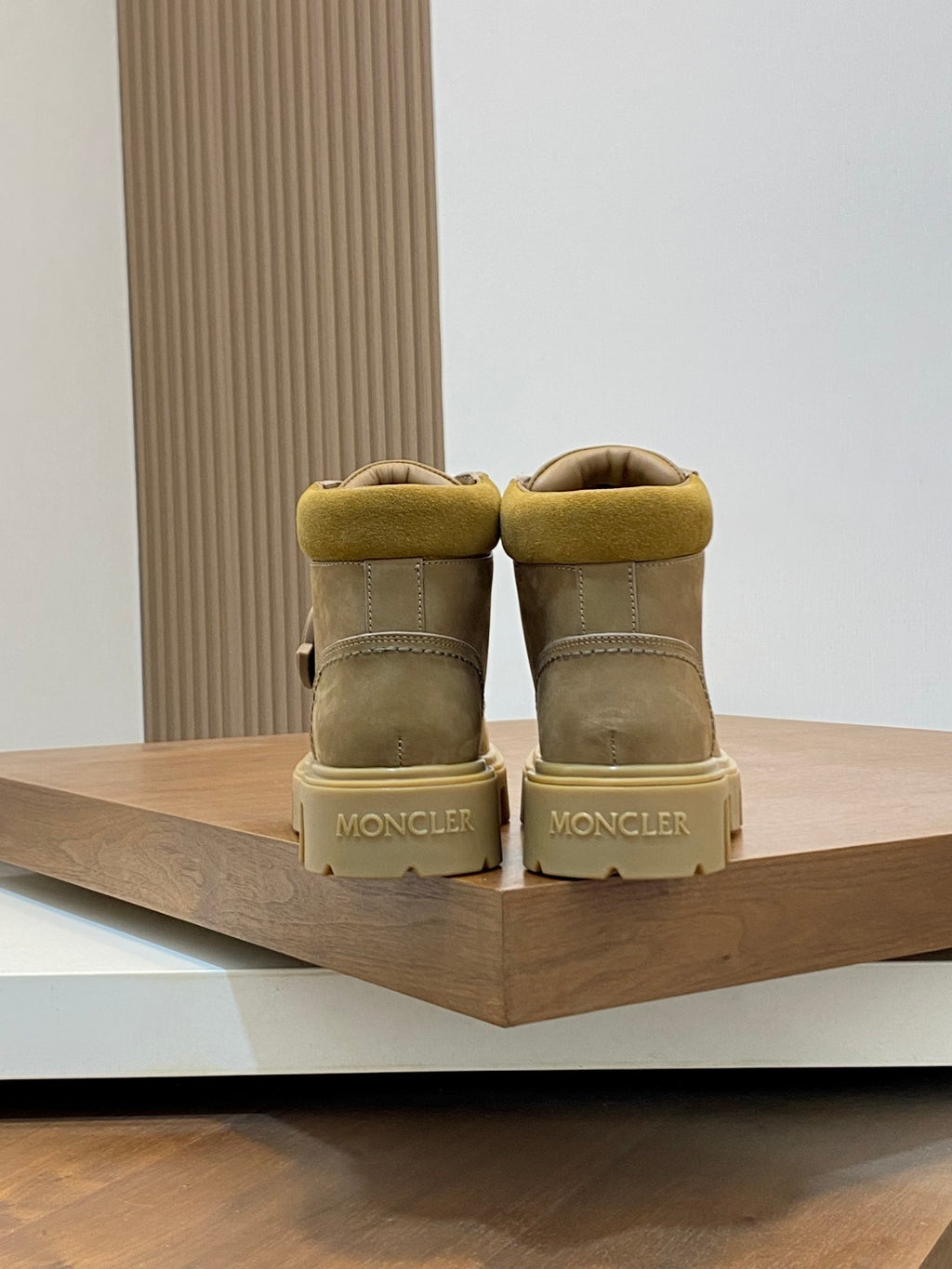 Back view of suede ankle boots with Moncler branding on the heel panels.