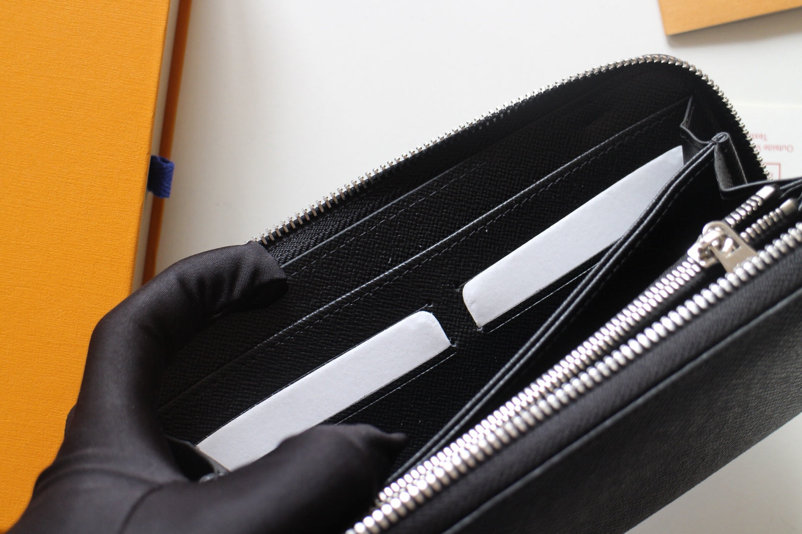 Louis Vuitton small zip bag open with black lining, card slots, and silver zipper