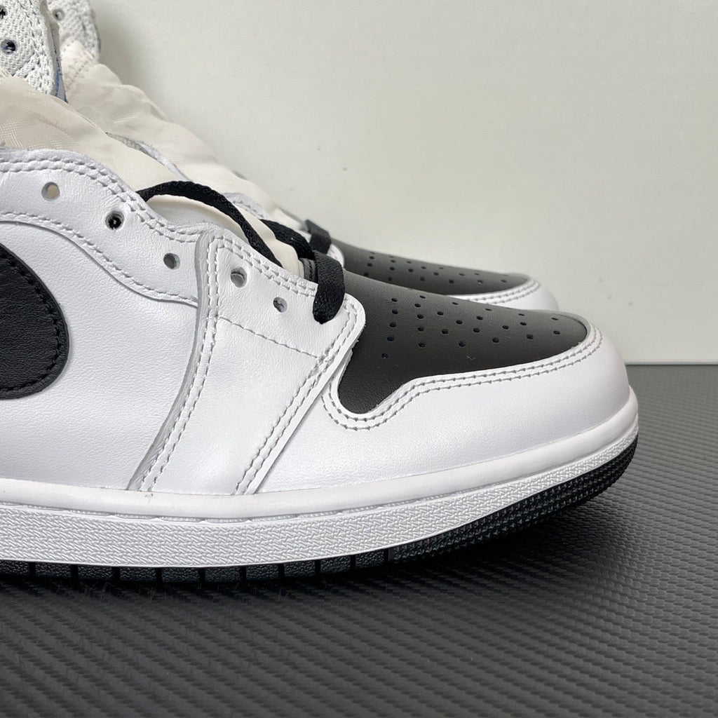 Side view of white and black high-top sneakers with perforated toe and black eyestay