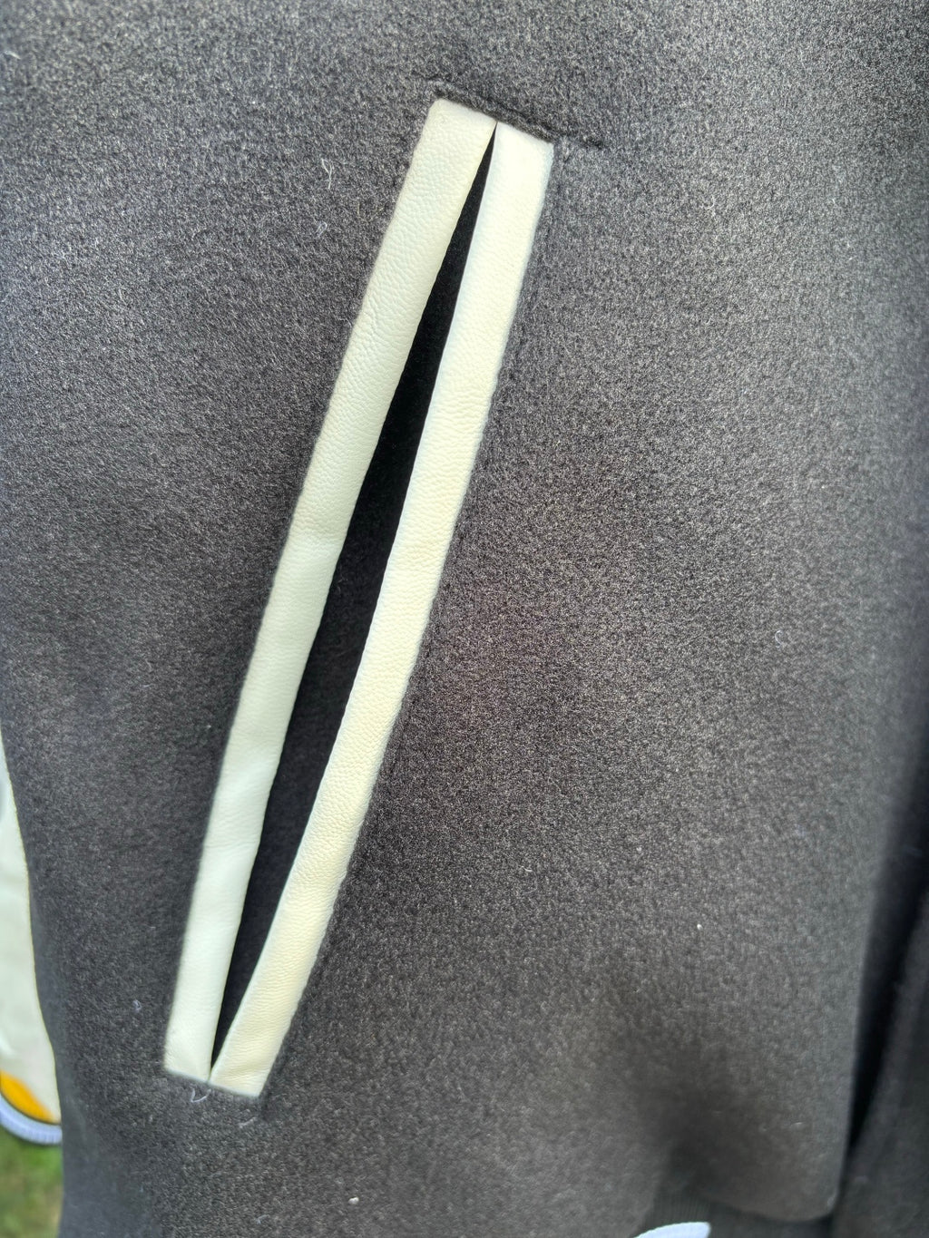 Varsity jacket sleeve close-up with long white stripe and ribbed dark cuff