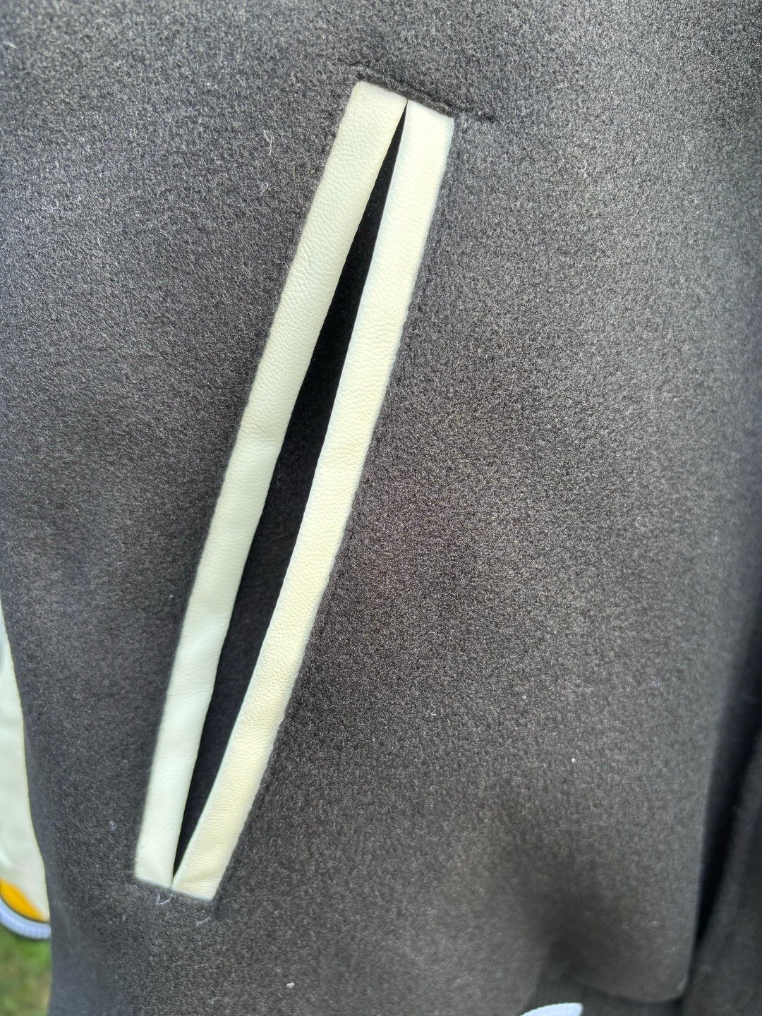 Varsity jacket sleeve close-up with long white stripe and ribbed dark cuff