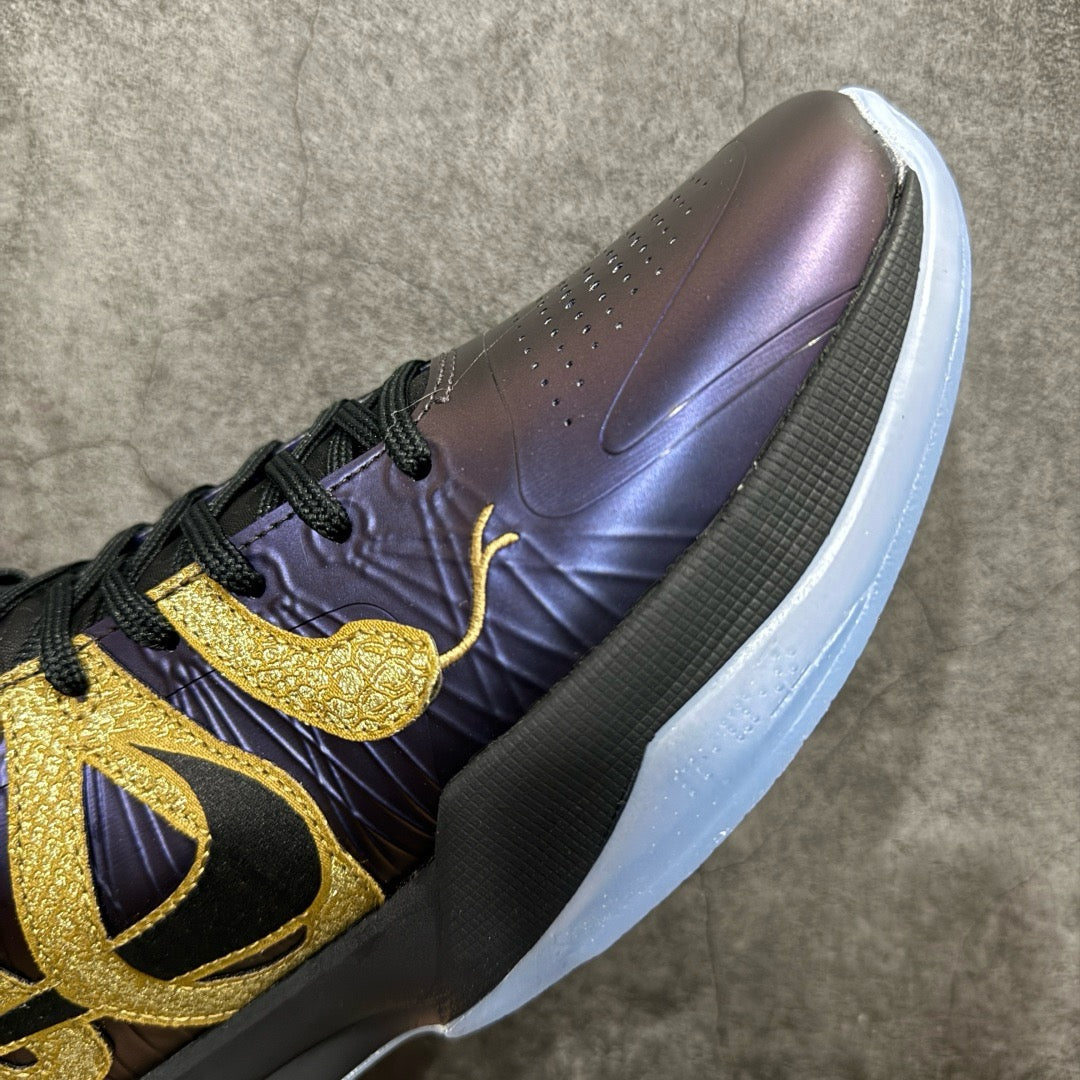 Basketball sneaker close-up of side panel in dark purple with gold swoosh detail