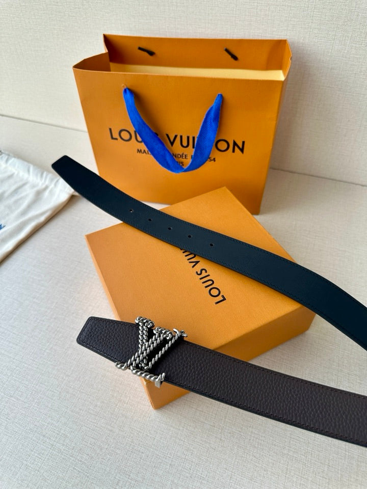 Louis Vuitton belt detail: dark leather strap with metallic chain buckle