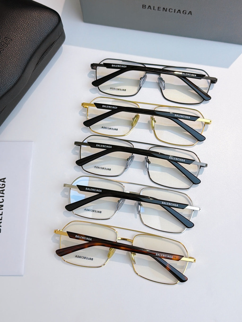 Assorted eyeglasses lineup with clear lenses in black and gold tones.