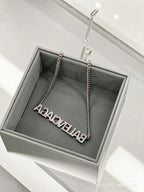 Silver Balenciaga logo pendant necklace in a gray gift box