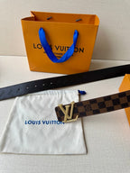 Louis Vuitton belt with Damier check strap and gold V buckle on white dust bag