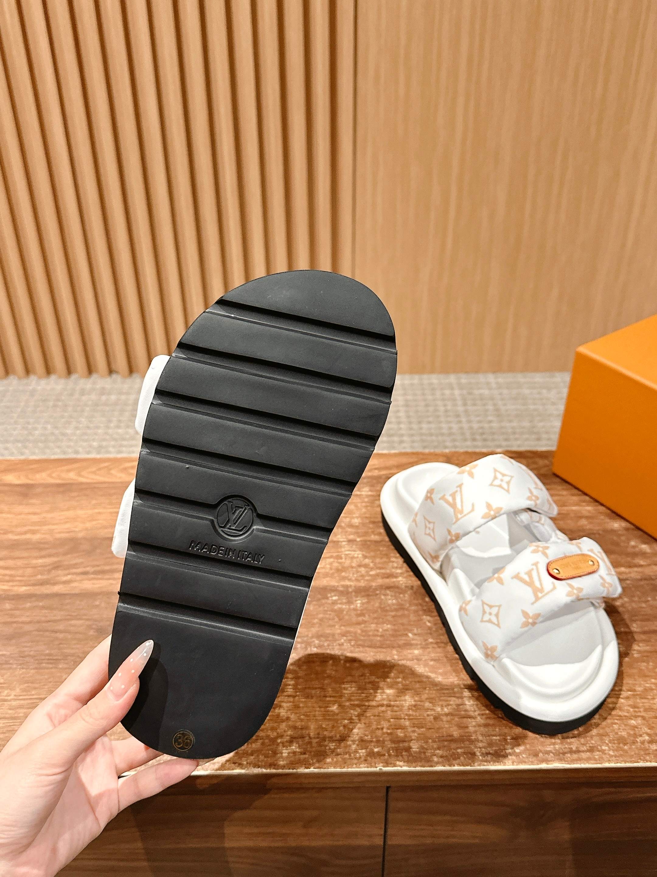 Black rubber outsole of Louis Vuitton slide sandal with tread pattern and logo