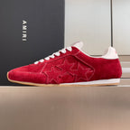 Red suede Amiri low-top sneakers with white laces, star pattern on side