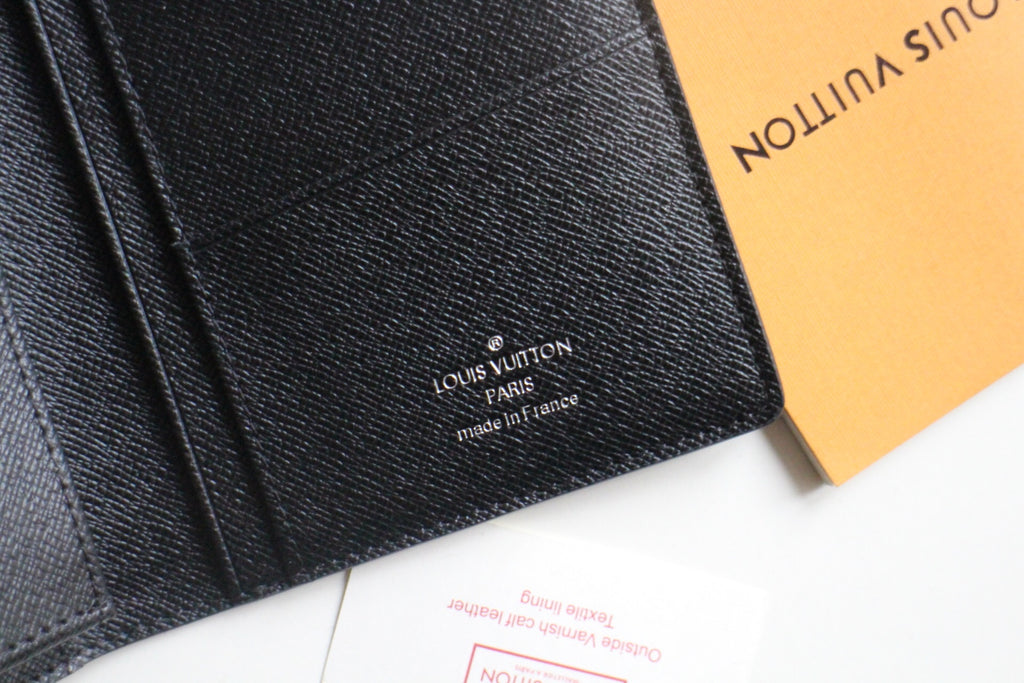 Louis Vuitton small wallet close-up with stitched logo on black leather