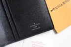 Louis Vuitton small wallet close-up with stitched logo on black leather