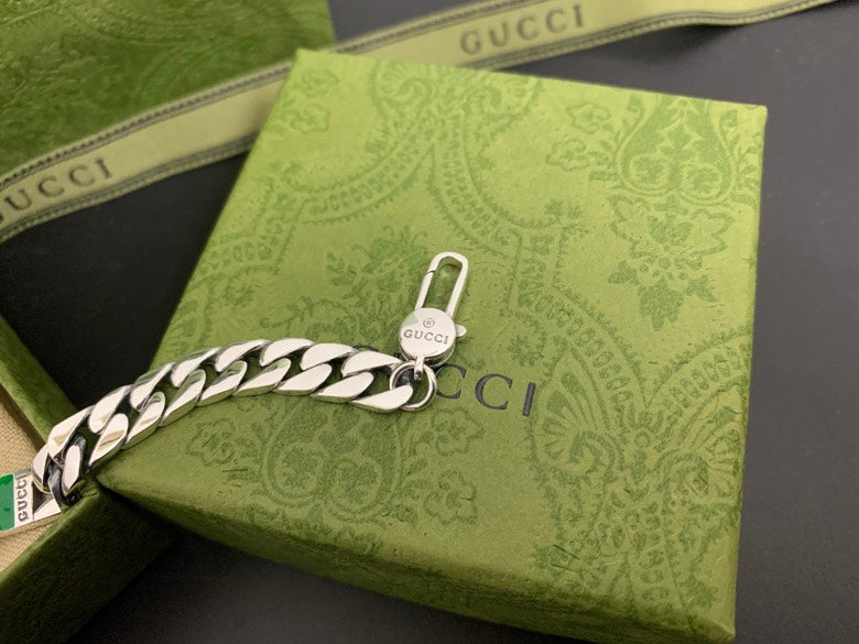 Silver chain bracelet with white leather panel and dangling Gucci charm, lobster clasp